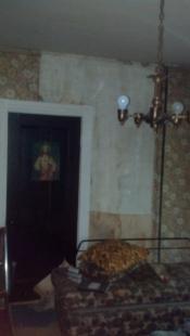Before bedroom with pealed wallpaper and door with image of Jesus