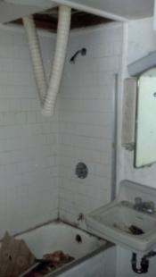 Before bathtub with plumbing coming down from ceiling