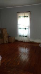 After room with clean hardwood floors and curtains