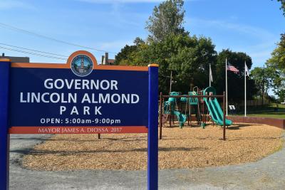 Playground with sign - "Governor Lincoln Almond Park, Open: 5 am - 9pm, Mayor James A. Diossa 2017