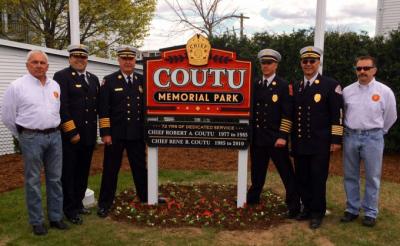 Officials and sign - "Coutu Memorial Park, 72 yrs of dedicated service, Chief Robert A. Coutu 77-85, Chief Rene R. Coutu 85-10